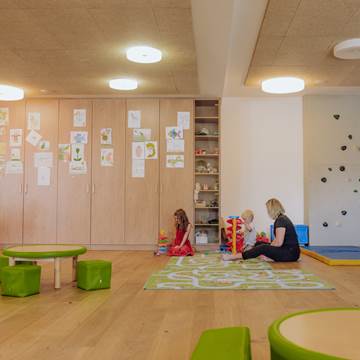 Eine Frau spielt mit zwei kleinen Kindern im Kinderspielraum des Hotels.