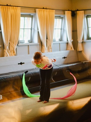 Kind bei der Aufführung mit Bewegungsbändern im Eventchalet zur Zirkuswoche im Naturresort Puradies, Leogang, Salzburger Land Kind bei Aufführung mit Bewegungsbändern, Puradies Leogang
