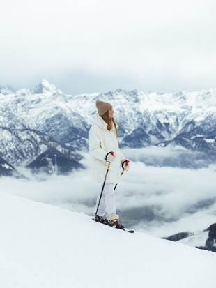 Person snowshoeing on mountain ridge above sea of clouds, Naturresort Puradies