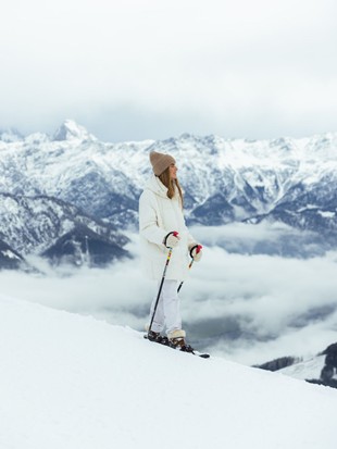 Person mit Schneeschuhen am Berggrat über Wolkenmeer, Naturresort Puradies