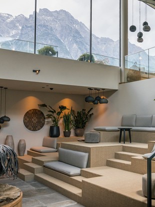 Kaminlounge im Hotel Puradies mit Glasfront und Blick auf die Berge.