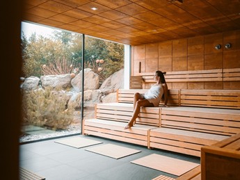 Entspannung in der Sauna des Adults-Only Saunahauses Person entspannt auf Holzbank in der Sauna, Adults-Only Saunahaus