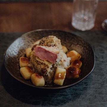 Schön angerichtete Speise mit Fleisch und kleinen Kartoffeln.