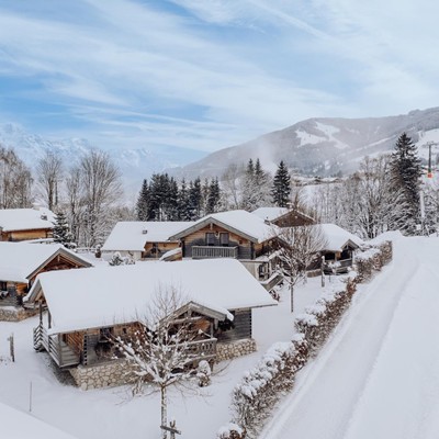 Snow-covered chalet village with mountain panorama, Naturresort Puradies