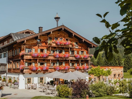 Embachhof im Sommer – Teil des Naturresorts Puradies Embachhof, Teil des Naturresorts Puradies in Leogang, mit Blumenbalkonen im Sommer.