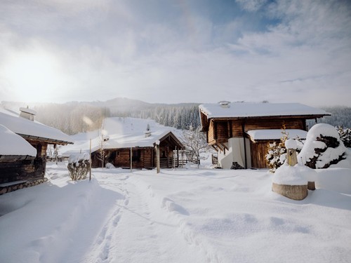 Verschneite Chalets im Winter bei Sonnenschein – Naturresort Puradies, Leogang, Salzburger Land Verschneite Chalets im Winter bei Sonnenschein, Puradies Leogang