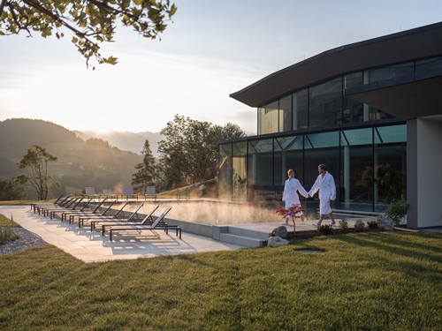 Two People in Bathrobes Walking Hand in Hand by the Infinity Pool of the Heaven Spa Two people in bathrobes walking hand in hand by the infinity pool of the Heaven Spa