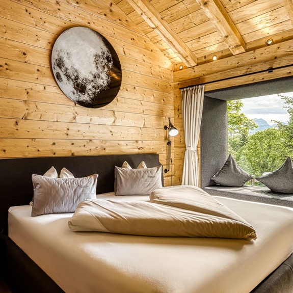 Schlafzimmer im Privat Spa Chalet x Moroso des Puradies Leogang Schlafzimmer im Privat Spa Chalet Puradies x Moroso des Puradies Naturresort mit großem Doppelbett und Holzelementen