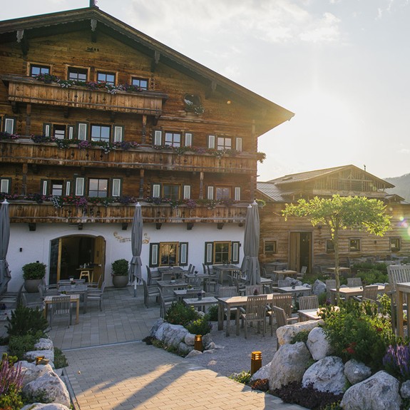 Das Hotel im Sommer, mit Terrasse im Vordergrund.