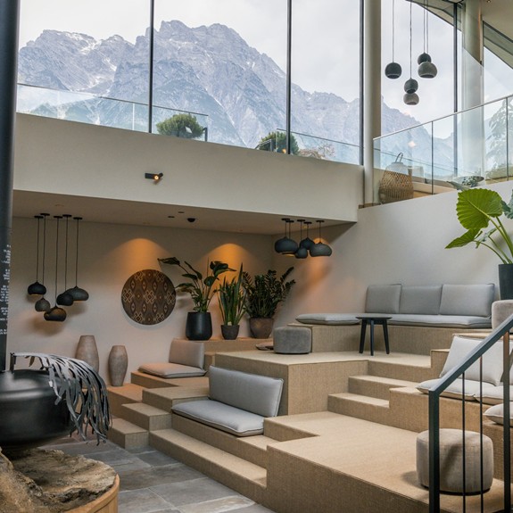 Kaminlounge im Hotel Puradies mit Glasfront und Blick auf die Berge.