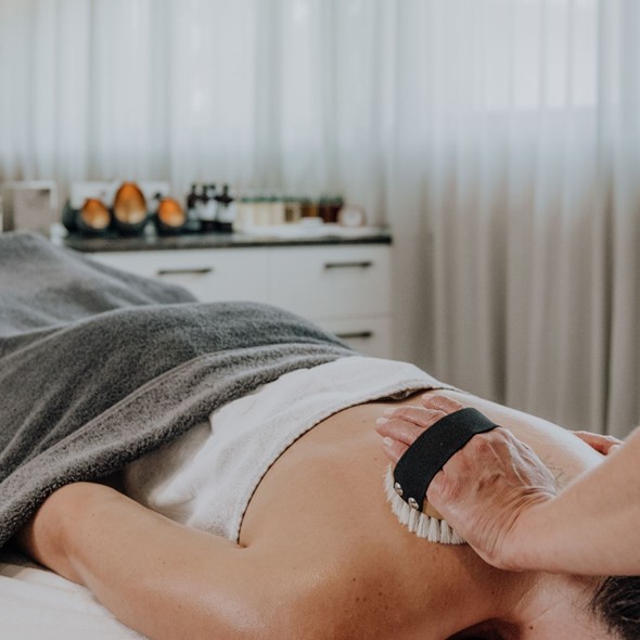 Massage & Spa-Behandlungen im Naturresort Puradies Leogang Eine Frau erhält eine Rückenmassage.