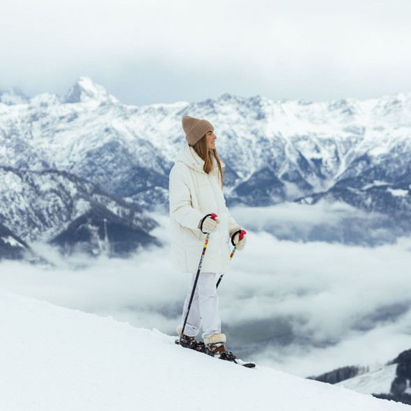 Person snowshoeing on mountain ridge above sea of clouds, Naturresort Puradies