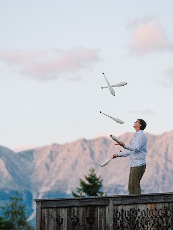 Jonglage mit Keulen auf der Terrasse des Eventchalets im Naturresort Puradies, Leogang, Salzburger Land Person jongliert Keulen auf Eventchalet-Terrasse, Puradies Leogang