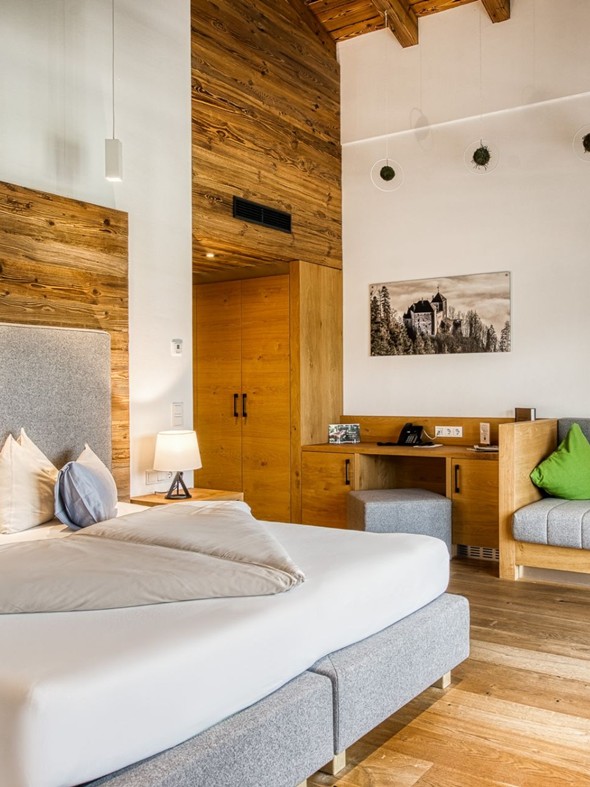 Doppelbett mit Sitzbank und Kleiderschrank in der Privat Spa Suite Wolke 7 im Naturresort Puradies Doppelbett mit Sitzbank und Kleiderschrank in der Privat Spa Suite Wolke 7 im Naturresort Puradies