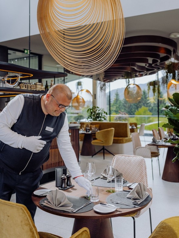 Service beim Eindecken eines Tisches im Ess:enz – Naturresort Puradies, Leogang, Salzburger Land Service beim Eindecken eines Tisches, Ess:enz Naturresort Puradies in Leogang